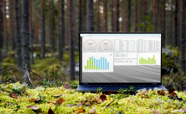 A laptop computer sitting on top of a moss covered field.