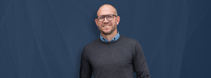 Johan Holmsten, global sales manager at Monitor ERP, standing infront of a blue background