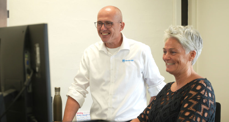 A man and a woman sitting in front of a computer.