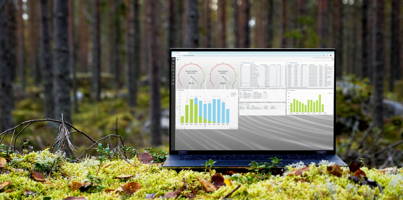 A laptop computer with Monitor ERP dashboard (sustainability functions) sitting on top of a moss covered field.