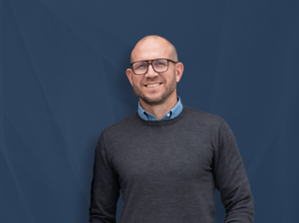 Johan Holmsten, Global Sales Manager bei Monitor ERP, steht vor einem blauen Hintergrund