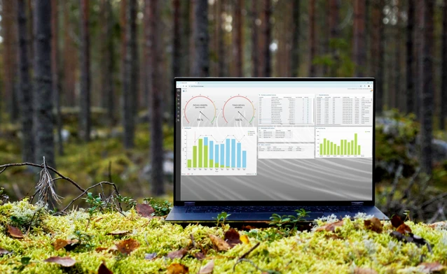 A laptop computer sitting on top of a moss covered field.