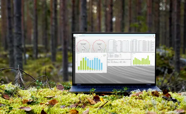 A laptop computer sitting on top of a moss covered field.