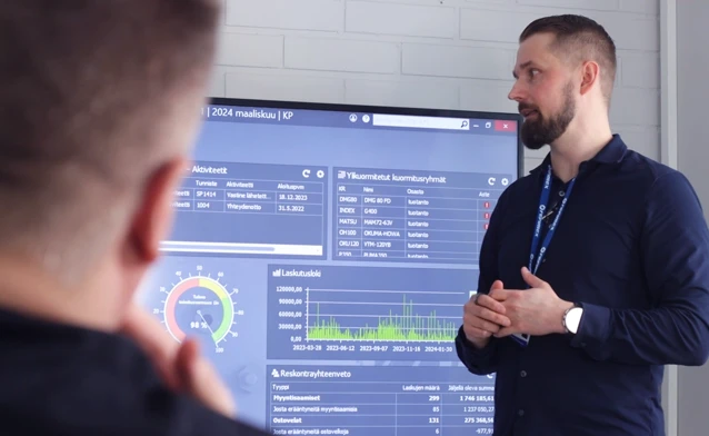 En man står framför en stor skärm som visar affärssystemet Monitor ERP.