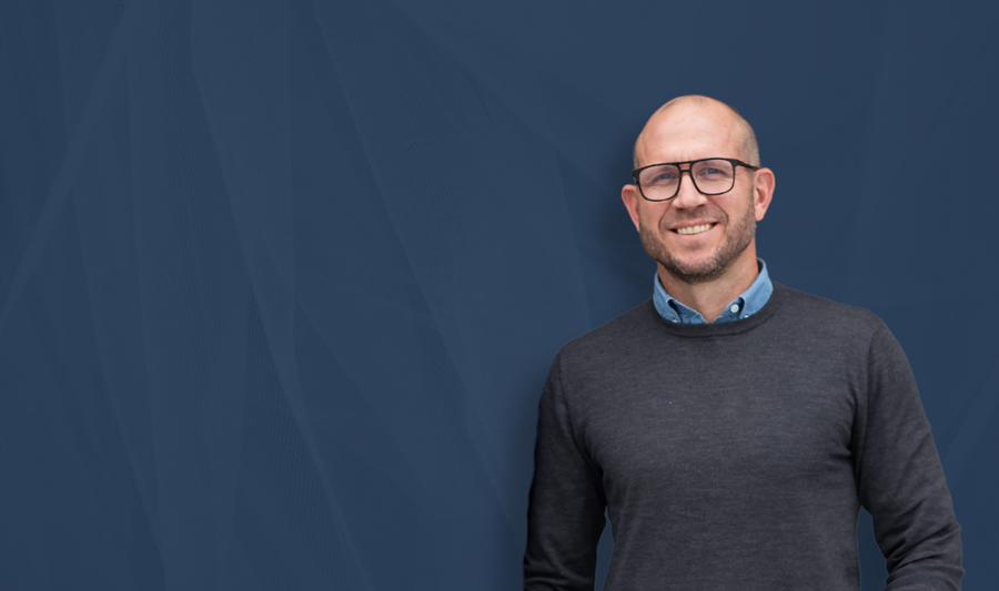 Johan Holmsten, Global Sales Manager, Monitor ERP, standing in front of a blue background.