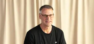 Dag Andesson from Hylte Paper AB is  sitting on a chair in front of a curtain.