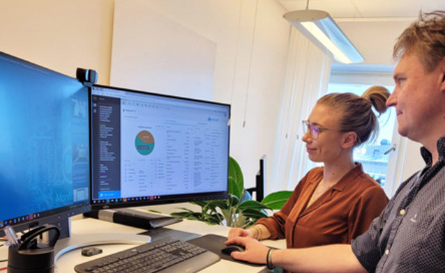 Dwoje ludzi przed ekranem, na którym uruchomiono system Monitor ERP.