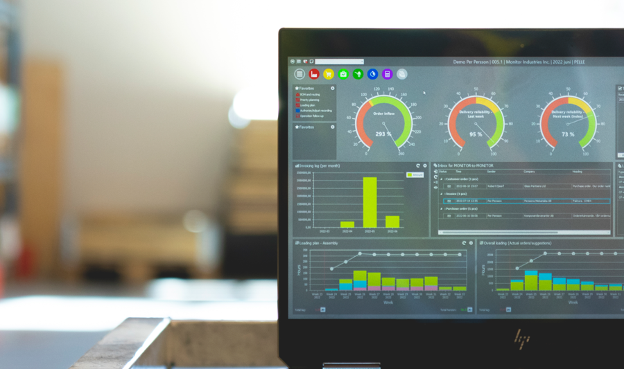 Monitor ERP dashboard visas på en bärbar dator i en fabriksmiljö.