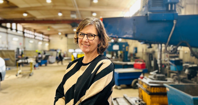 En kvinna står i en fabrik.