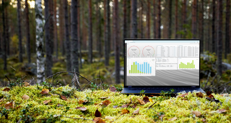 A laptop computer with Monitor ERP dashboard (sustainability functions) sitting on top of a moss covered field.