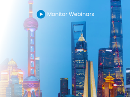 A picture of a city at night with the words monitor webinars.