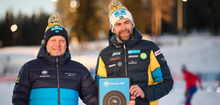 Two men standing next to each other holding a plaque.
