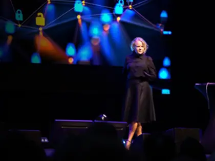 A woman standing on a stage in front of a crowd.