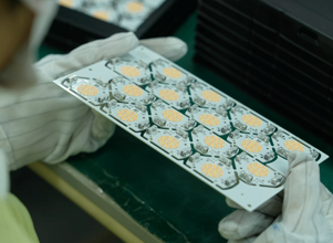 A person in white gloves holding a box of pills.