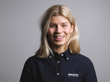 A woman in a black shirt is smiling.