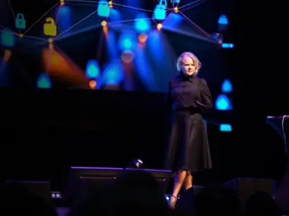 A woman standing on a stage in front of a crowd.
