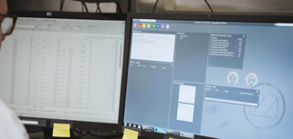 A man sitting in front of two computer monitors.