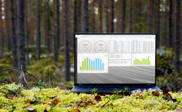 A laptop computer sitting on top of a moss covered field.