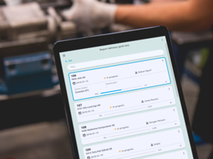 A person holding a tablet computer in a factory.