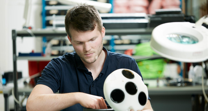 En man som håller en vit boll med hål i.