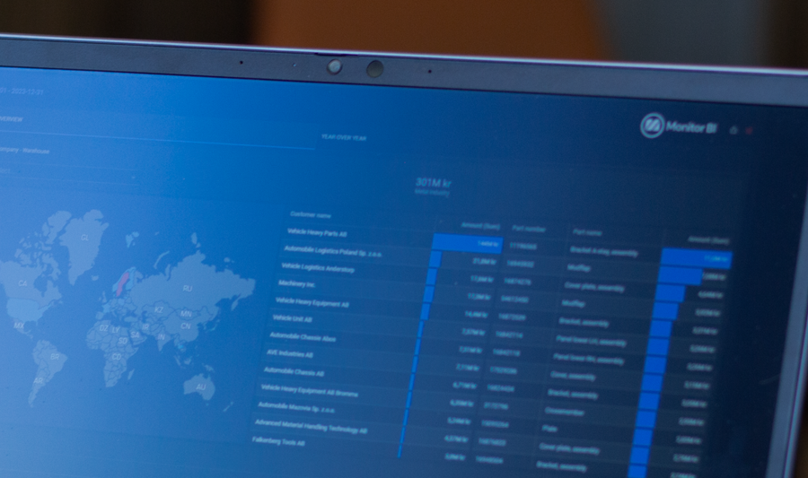 A person sitting in front of a laptop computer with Monitor BI (business intelligence) dashboards. 