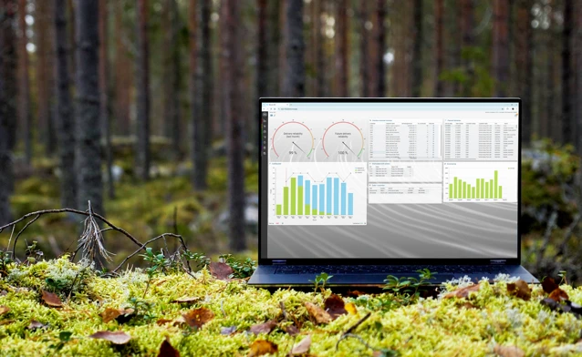 A laptop computer sitting on top of a moss covered field.