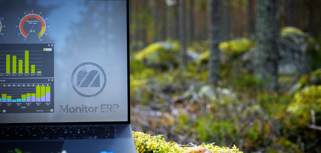 Illustration of Monitor ERP dashboards on a screen placed in nature, symbolizing sustainability.
