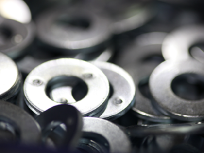 A pile of metal washers sitting on top of a table.