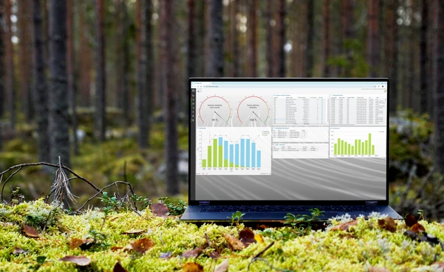 A laptop computer sitting on top of a moss covered field.