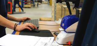 A man working on a computer in a factory.