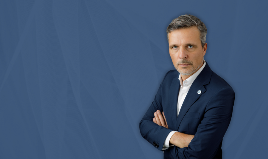 Maciej Swienton, CEO Monitor ERP System Polska, na niebieskim tle.