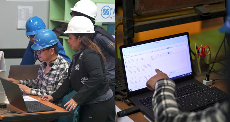A group of people in hard hats working on laptops.
