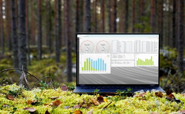 A laptop computer sitting on top of a moss covered field.