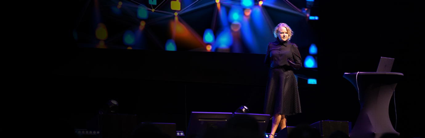 A woman standing on a stage in front of a crowd.
