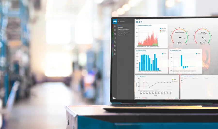System Monitor ERP wyświetlony na ekranie laptopa, w tle hala produkcyjna.