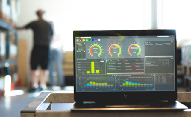 Monitor ERP dashboard displayed on a laptop in a factory environment