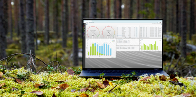 A laptop computer with Monitor ERP dashboard (sustainability functions) sitting on top of a moss covered field.