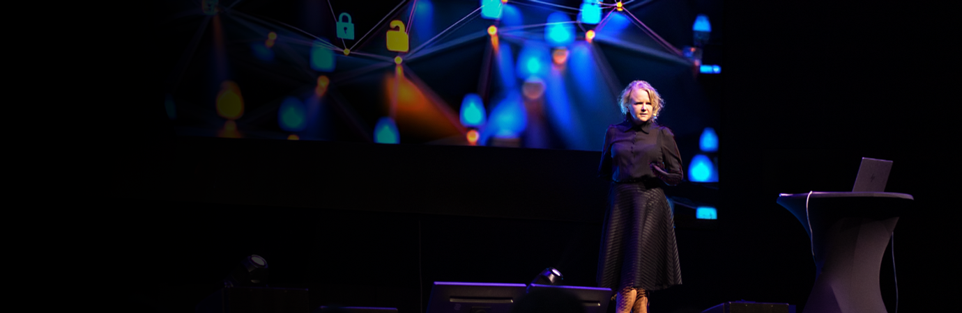 A woman standing on a stage in front of a crowd.