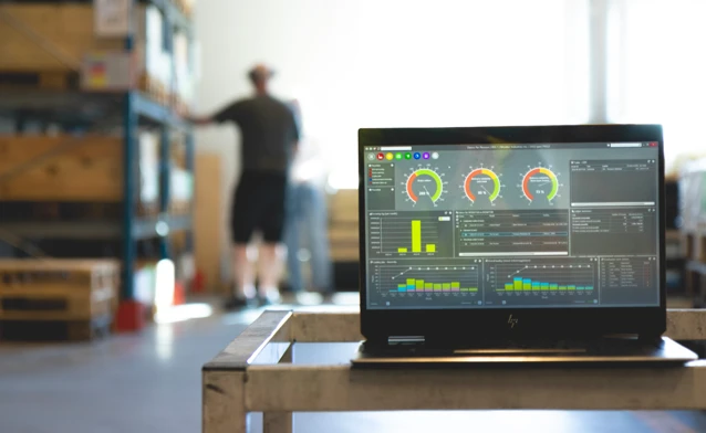 Monitor ERP dashboard displayed on a laptop in a factory environment