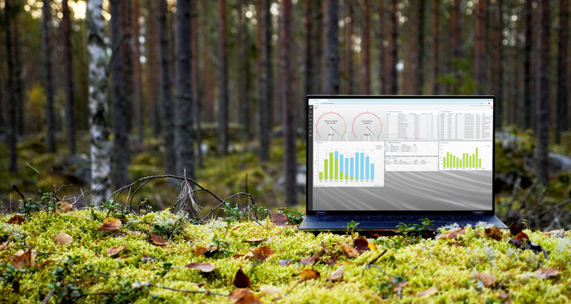 A laptop computer sitting on top of a moss covered field.