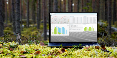A laptop computer sitting on top of a moss covered field.