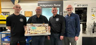 Employees from Lund Maskinfabrik A/S are standing and holding up a cake with “Monitor ERP” written on it.