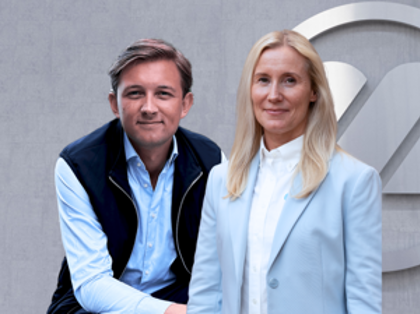 En kille och en tjej står framför en grå bakgrund.