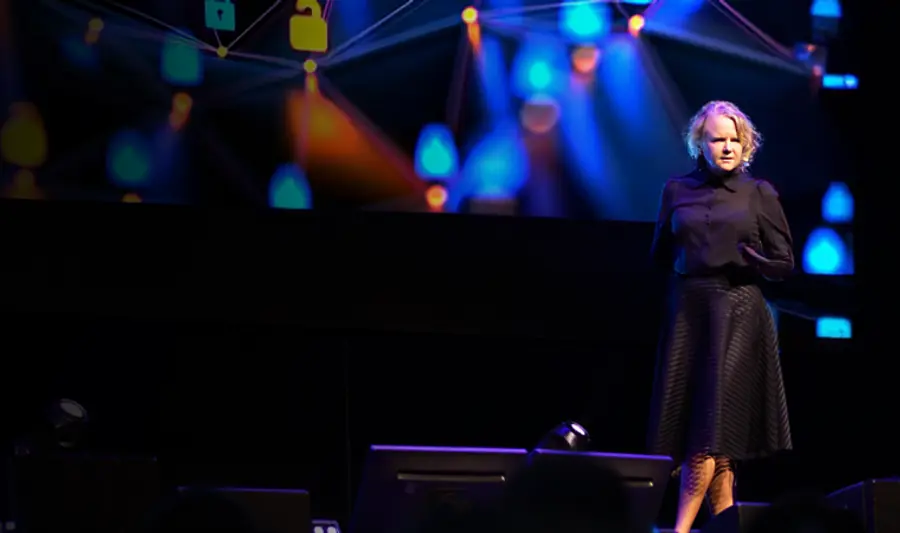A woman standing on a stage in front of a crowd.