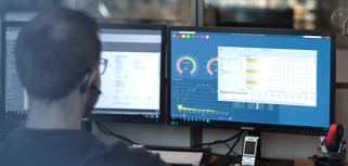 A man sitting in front of a computer monitor.