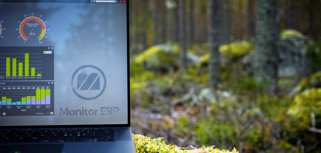 Illustration of Monitor ERP dashboards on a screen placed in nature, symbolizing sustainability.