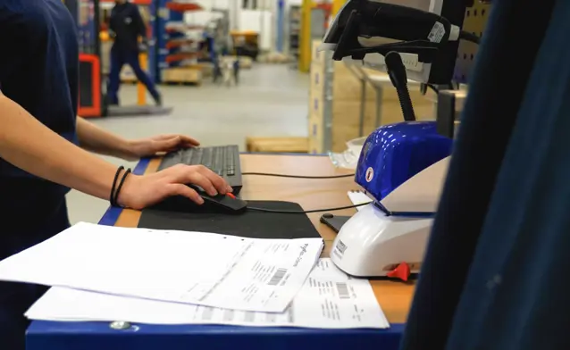 A man working on a computer in a factory.