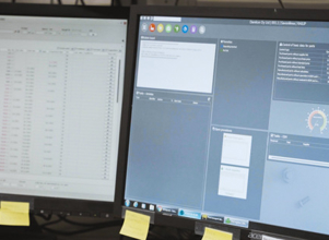 A man sitting in front of two computer monitors.