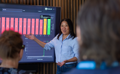 A woman at Monitor ERP giving a presentation to a group of people about Monitor BI (business intelligence)