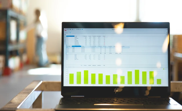 Monitor ERP dashboard displayed on a laptop in a factory environment
